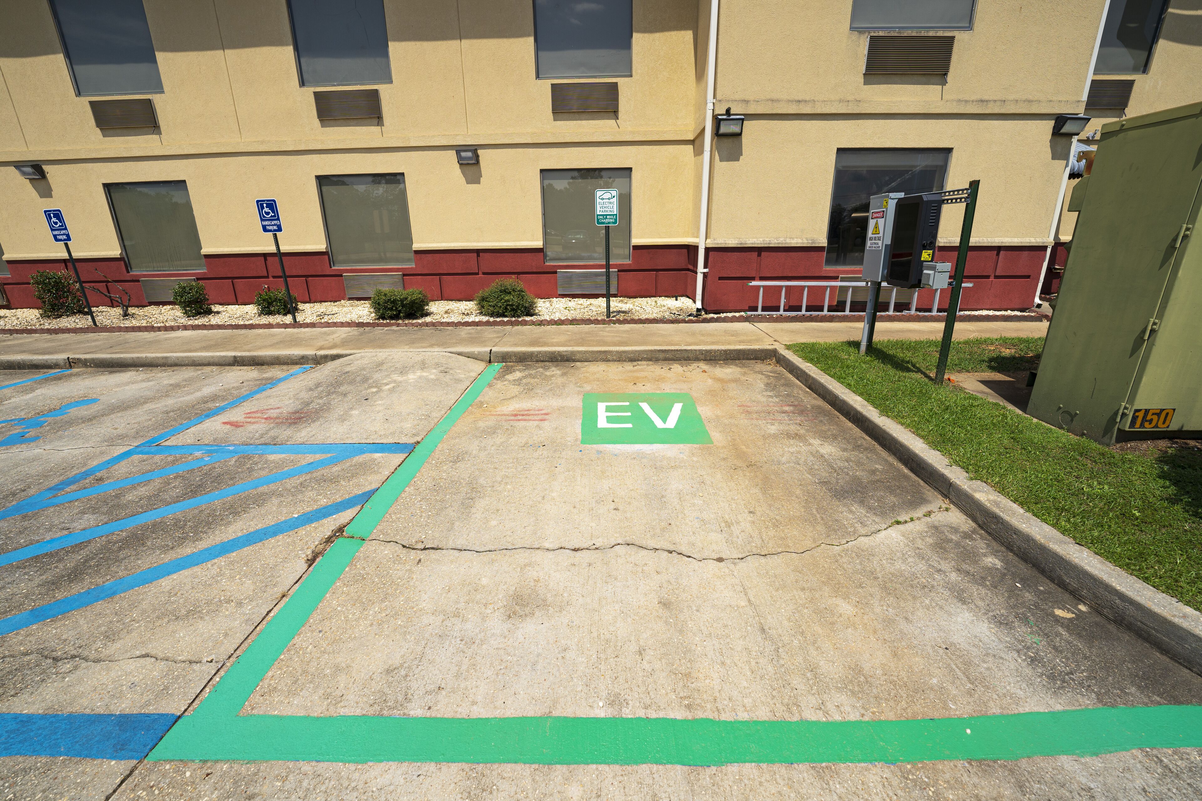 A parking area with designated spaces for electric vehicles and handicapped parking.