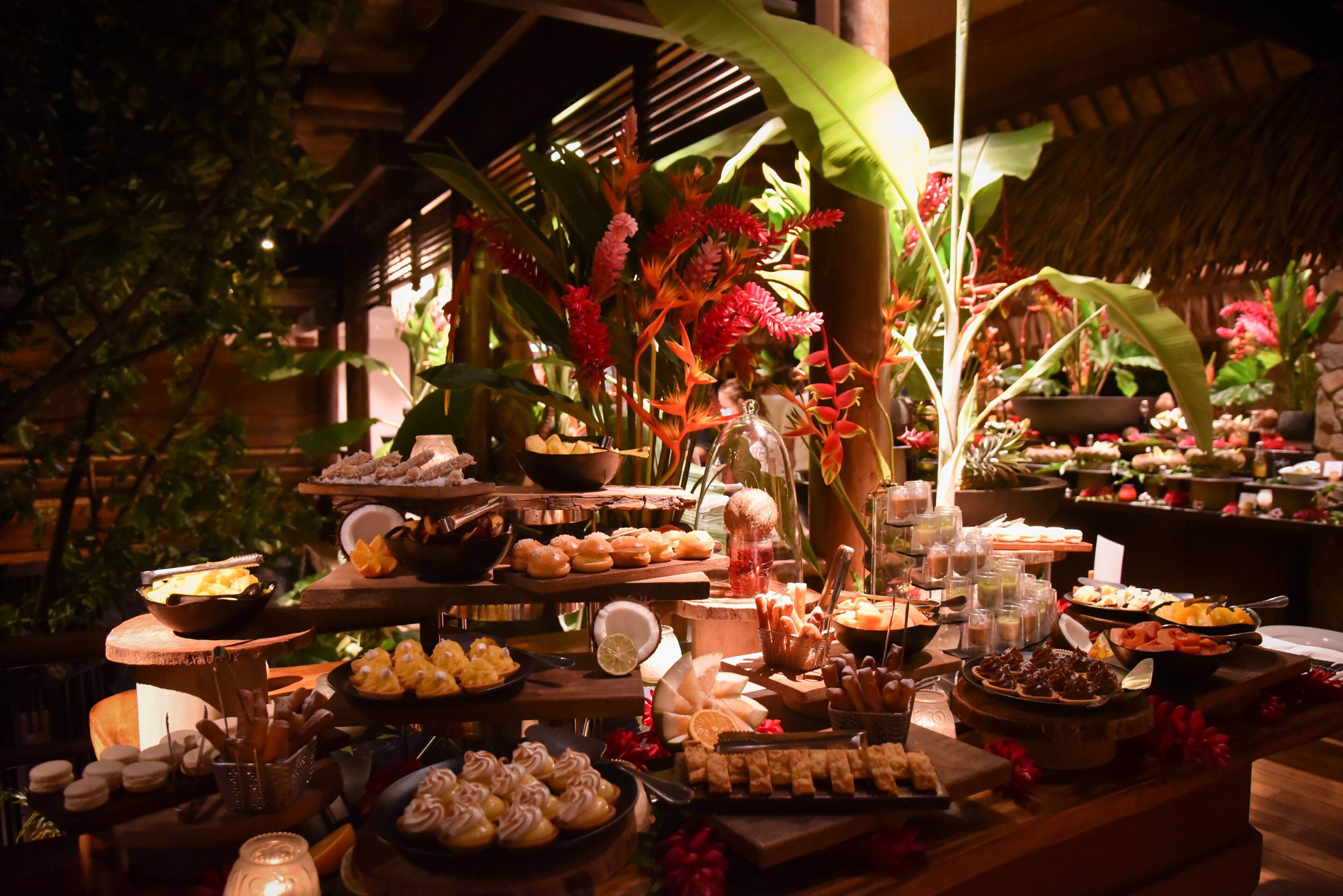 A buffet table with various food items and a decorative plant arrangement.