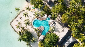 An aerial view of a resort with a swimming pool, palm trees, and beach access. - Le Taha'a by Pearl Resorts (Taha'a)