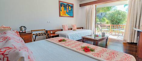 Habitación de hotel con dos camas, un cuadro en la pared, un balcón con vistas y una mesa con un arreglo floral.