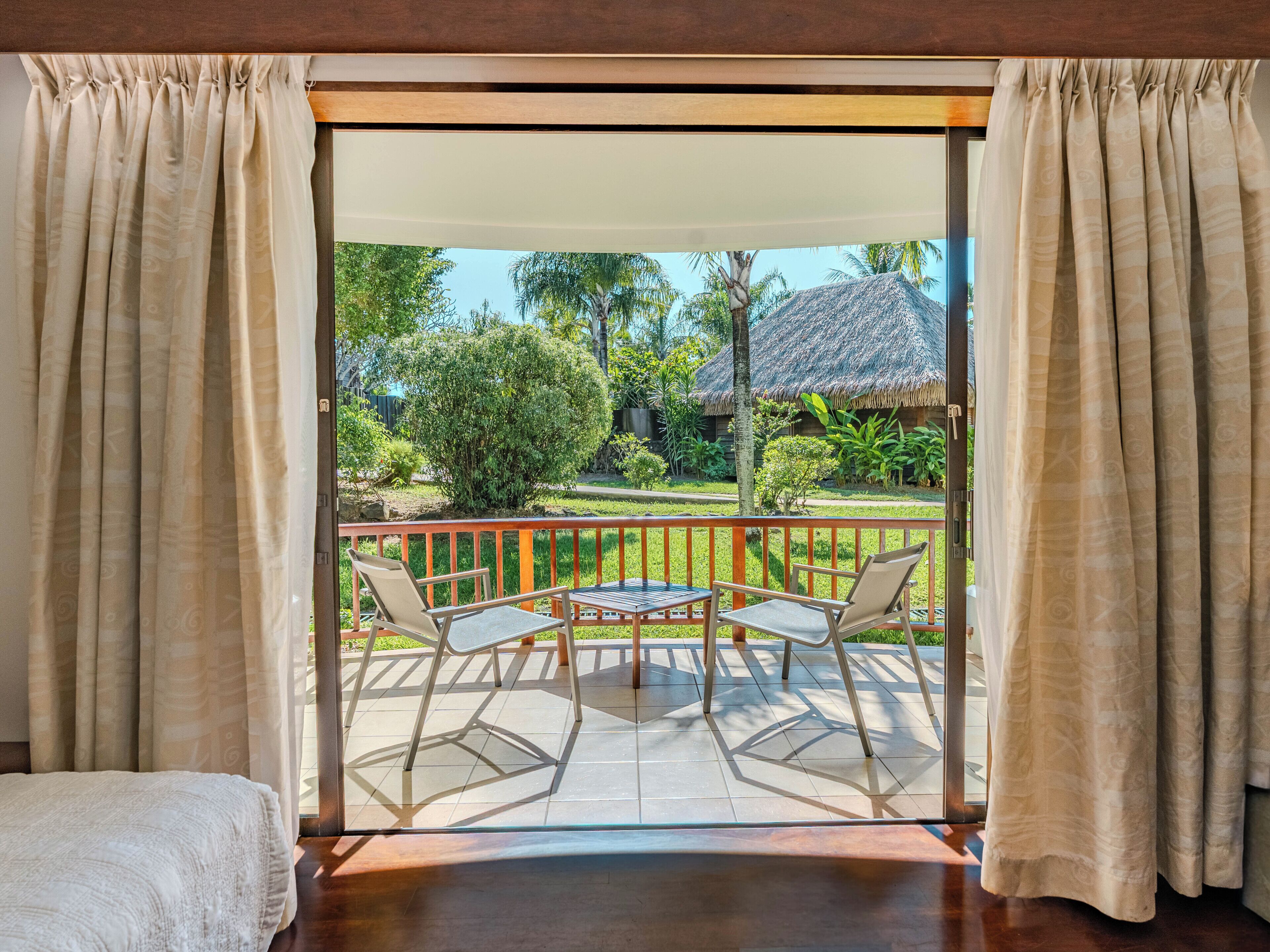 A room with a sliding glass door leading to an outdoor patio with two chairs and a table.