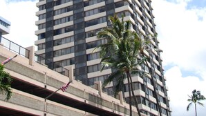 A tall, modern high-rise building with a grid-like facade and balconies. - Waikiki Monarch Hotel (Honolulu)