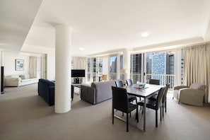 Una habitación de hotel espaciosa con balcón, comedor y sala de estar.