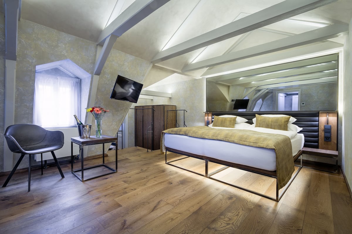 A modern bedroom with a bed, a desk, and a chair.