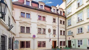 A historic building with multiple stories, ornate architectural details, and a cobblestone courtyard.