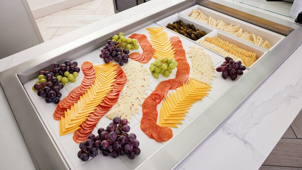 A buffet with various cheeses, cured meats, and grapes. - Staybridge Suites Silicon Valley by IHG (Milpitas)