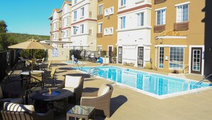 A poolside area with outdoor seating and a swimming pool. - Staybridge Suites Silicon Valley by IHG (Milpitas)