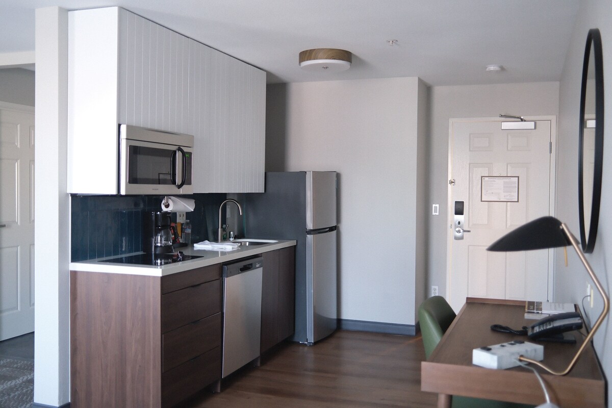 A compact kitchen with a microwave, refrigerator, and dishwasher.