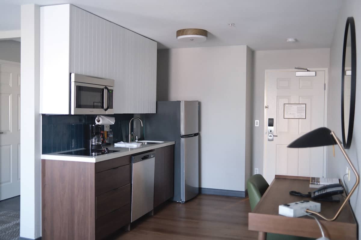 A compact kitchen with a microwave, refrigerator, and dishwasher.
