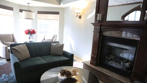 A living room with a green sofa, a glass coffee table, and a fireplace. - Staybridge Suites Silicon Valley by IHG (Milpitas)