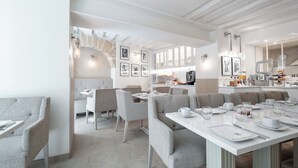 Un comedor moderno con techos altos, paredes de ladrillo visto y mobiliario contemporáneo.