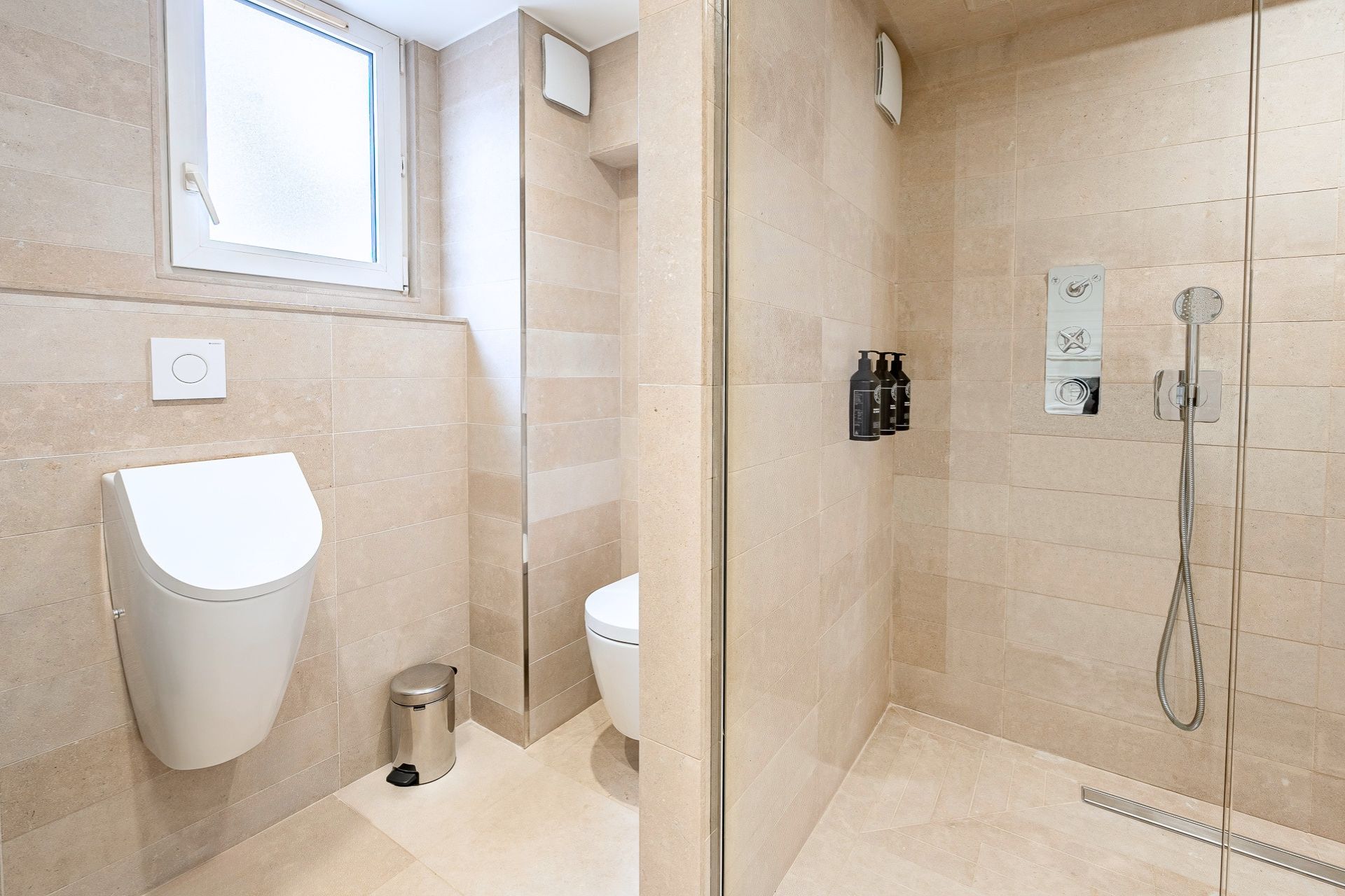 Ein modernes Badezimmer mit einer gläsernen Duschkabine, einer Toilette und einem Bidet.