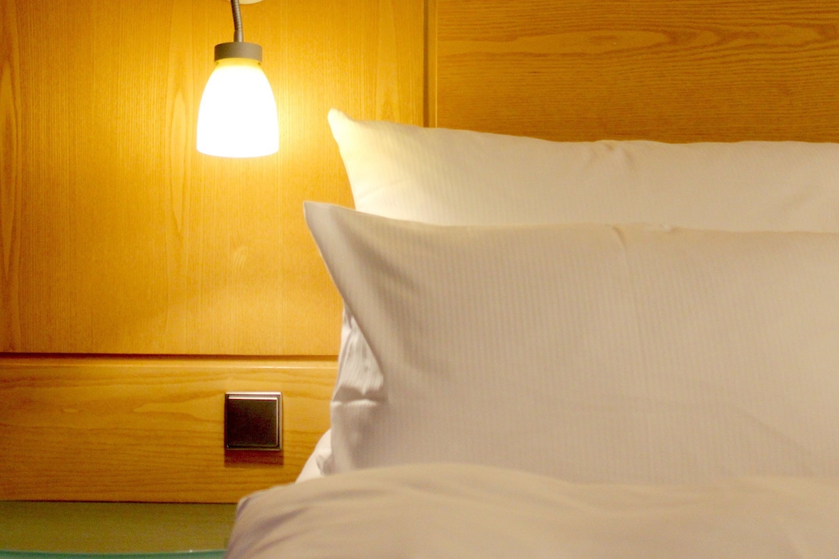 Un mur en bois avec un luminaire fixé au mur et un petit panneau de commande.