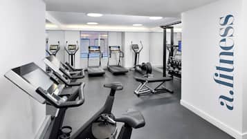 A gym with treadmills, elliptical machines, and weight benches.