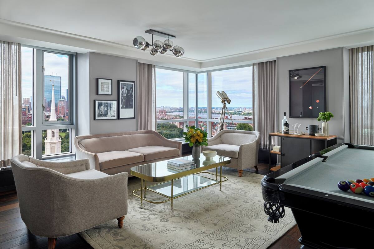 A modern living room with a pool table, a sofa, and a coffee table.