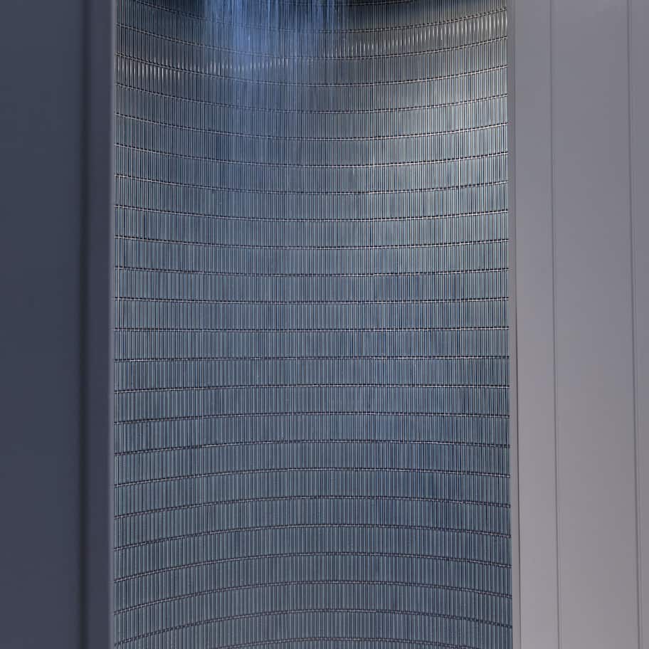 A modern bathroom with a vertical water feature and a circular floor.