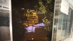 A balcony with a view of a historic building with illuminated windows and a large dome. - Old City Inn Hotel (Baku)