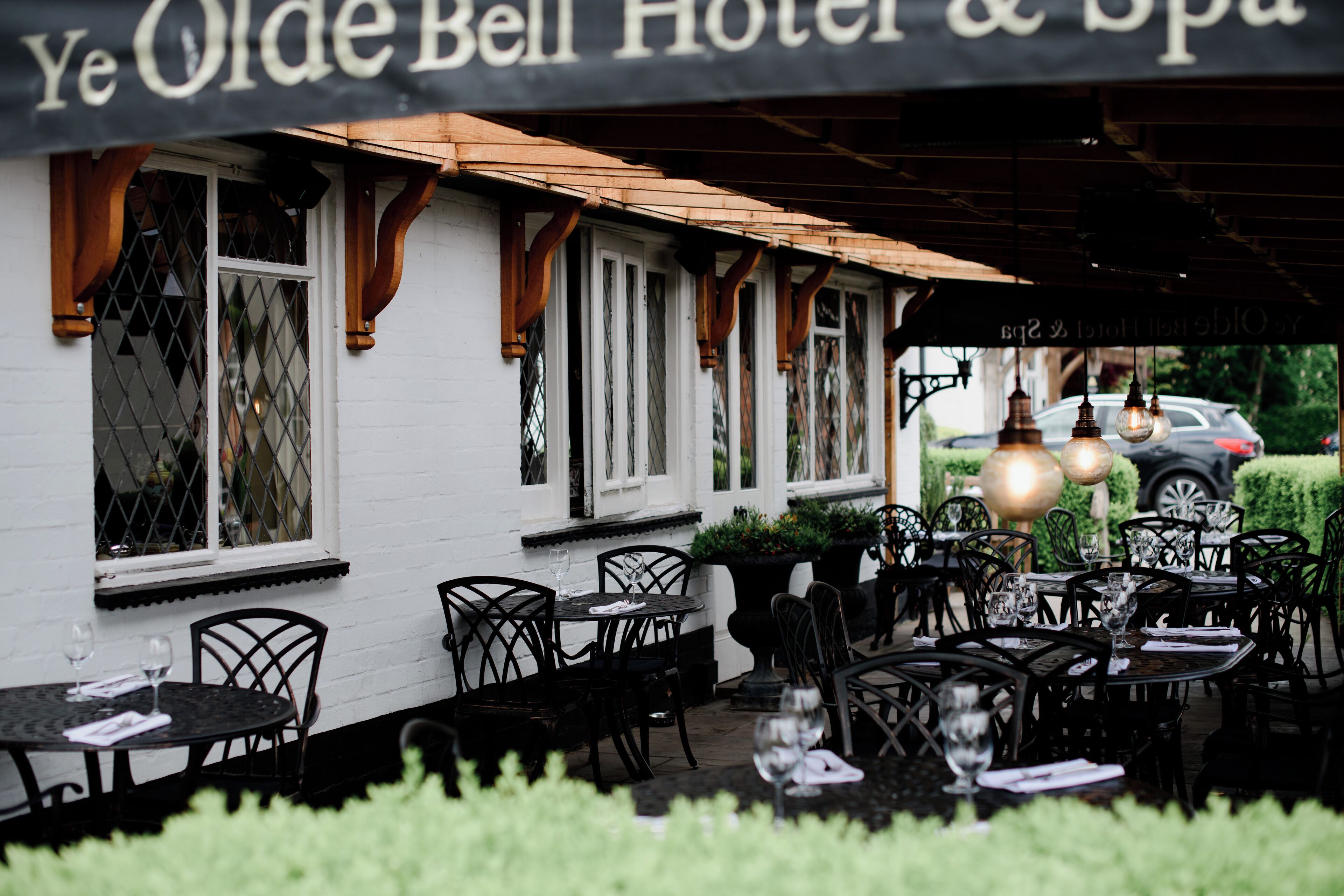 Zona exterior con mesas y sillas dispuestas para los huéspedes en el Hotel & Spa Ye Olde Bell.
