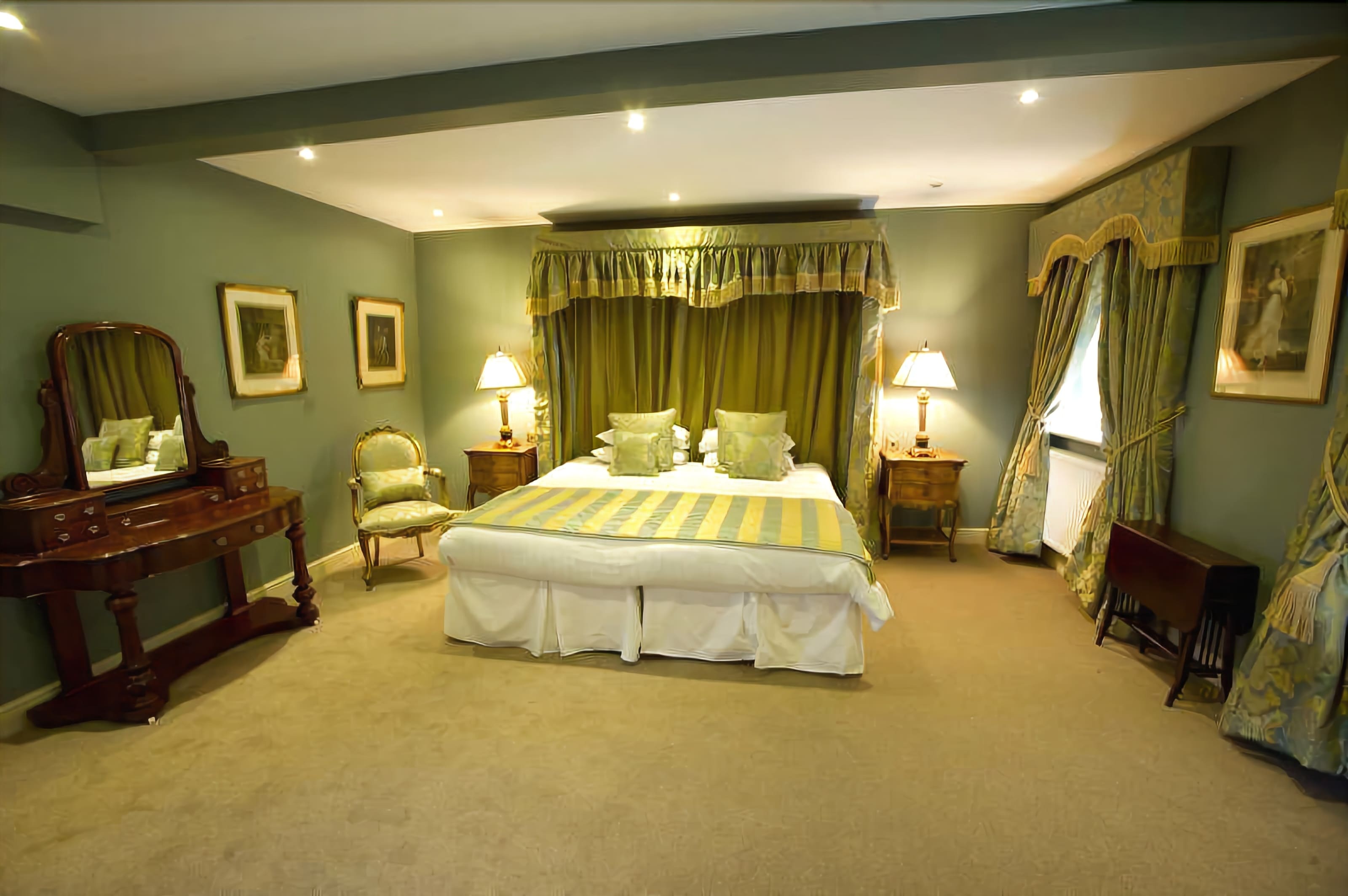 A bedroom with a large bed, two bedside tables, a dresser, a chair, and a mirror.
