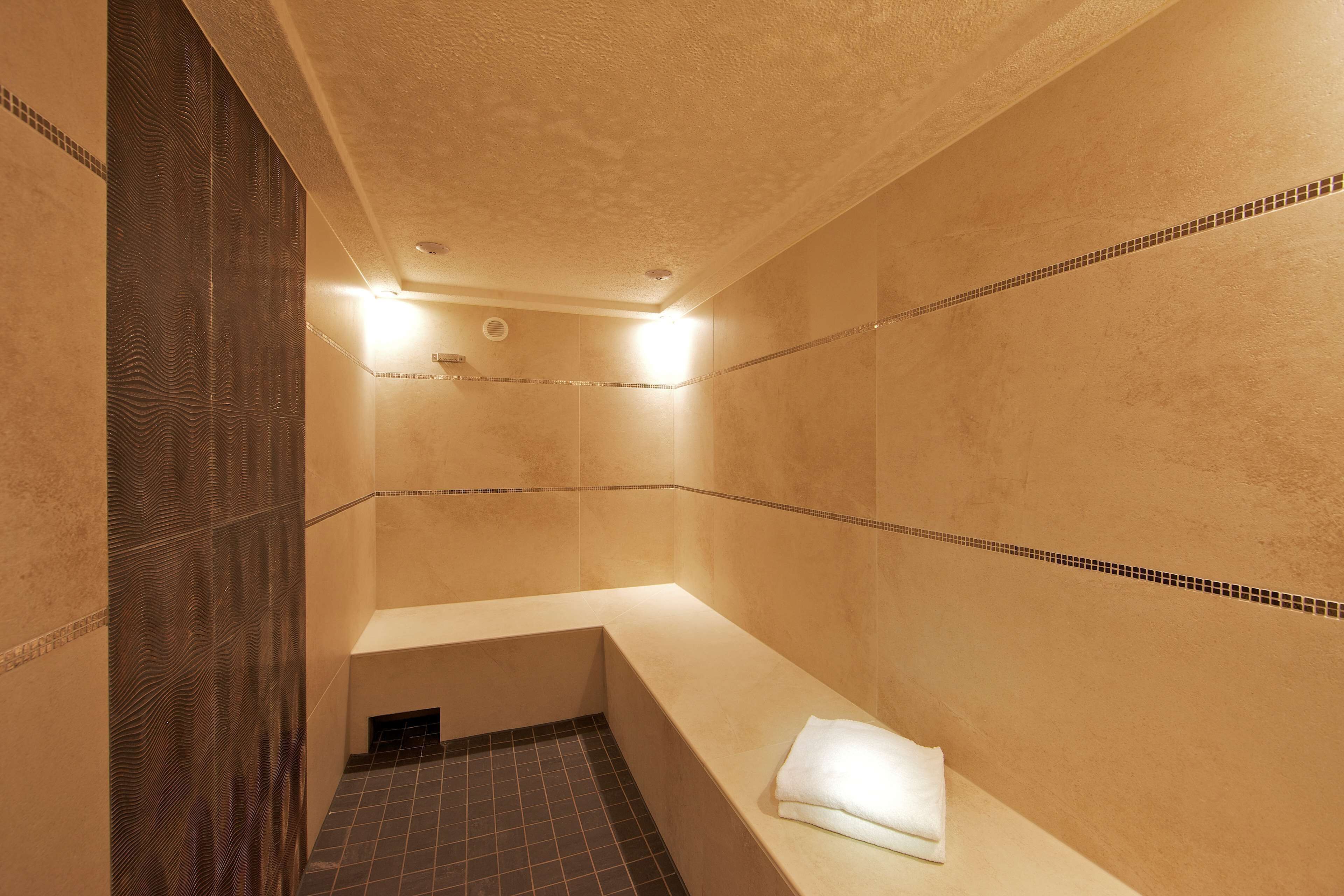 Een badkamer met een bad, douche en betegelde vloer.