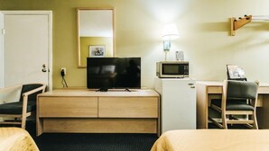 A hotel room with a bed, a desk with a chair, a television, a microwave, and a small refrigerator. - Knights Inn Berea (Berea)