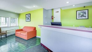 A reception area with a reception desk, a waiting area with a sofa, and a fire extinguisher on the wall. - Knights Inn Berea (Berea)