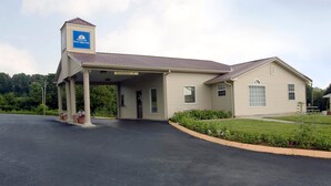 A two-story building with a covered entrance and a sign indicating a clearance of 9 feet.