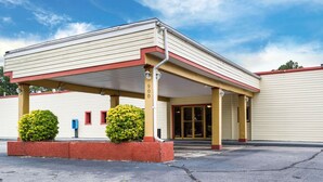 A building with a covered entrance, a number '900' sign, and two bushes in front. - Econo Lodge Petersburg - Fort Lee (Petersburg)