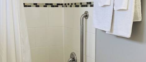 A bathroom with a shower, toilet, and sink.