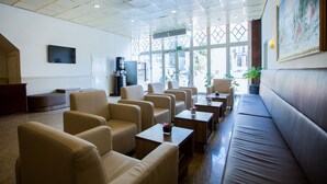 A hotel lobby with a seating area, a coffee machine, and a TV on the wall. - OZO Hotels Cordial Amsterdam (Amsterdam)