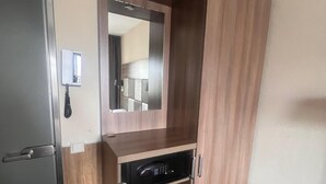 A room with a built-in wardrobe, a mirror, and a microwave. - OZO Hotels Cordial Amsterdam (Amsterdam)
