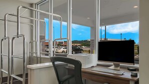 A modern office with a desk, computer, and metal handrails. - SureStay Plus Hotel by Best Western Sevierville (Sevierville)