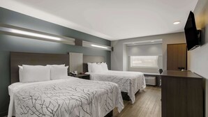 A hotel room with two beds, a desk, a flat-screen TV, and a window. - SureStay Plus Hotel by Best Western Sevierville (Sevierville)