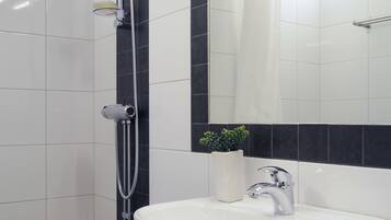 A bathroom with a shower, sink, and mirror.