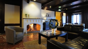 Un hall con chimenea, zona de estar y un mostrador de recepción.