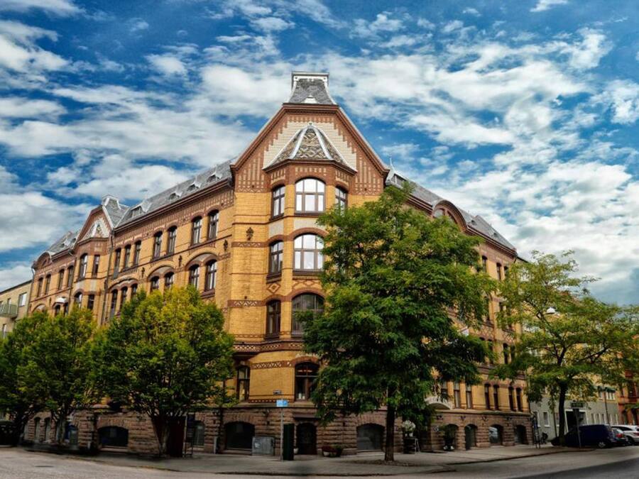 A large, historic building with a prominent corner turret and arched windows.