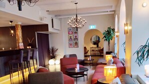 Un espace de détente moderne avec des canapés, un bar et un lustre.