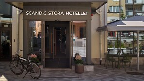 The entrance to Scandic Stora Hotellet with a bicycle parked outside and a potted plant in front. - Scandic Stora Hotellet (Nykoping)