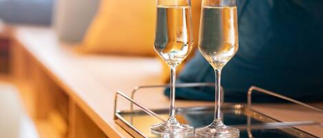 Two glasses of champagne on a tray on a wooden table.
