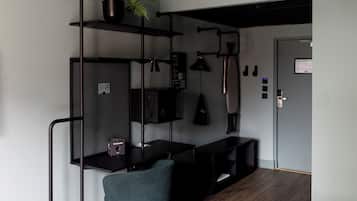 Ein modernes, kompaktes Zimmer mit Schreibtisch, Regalen und einem Stuhl.