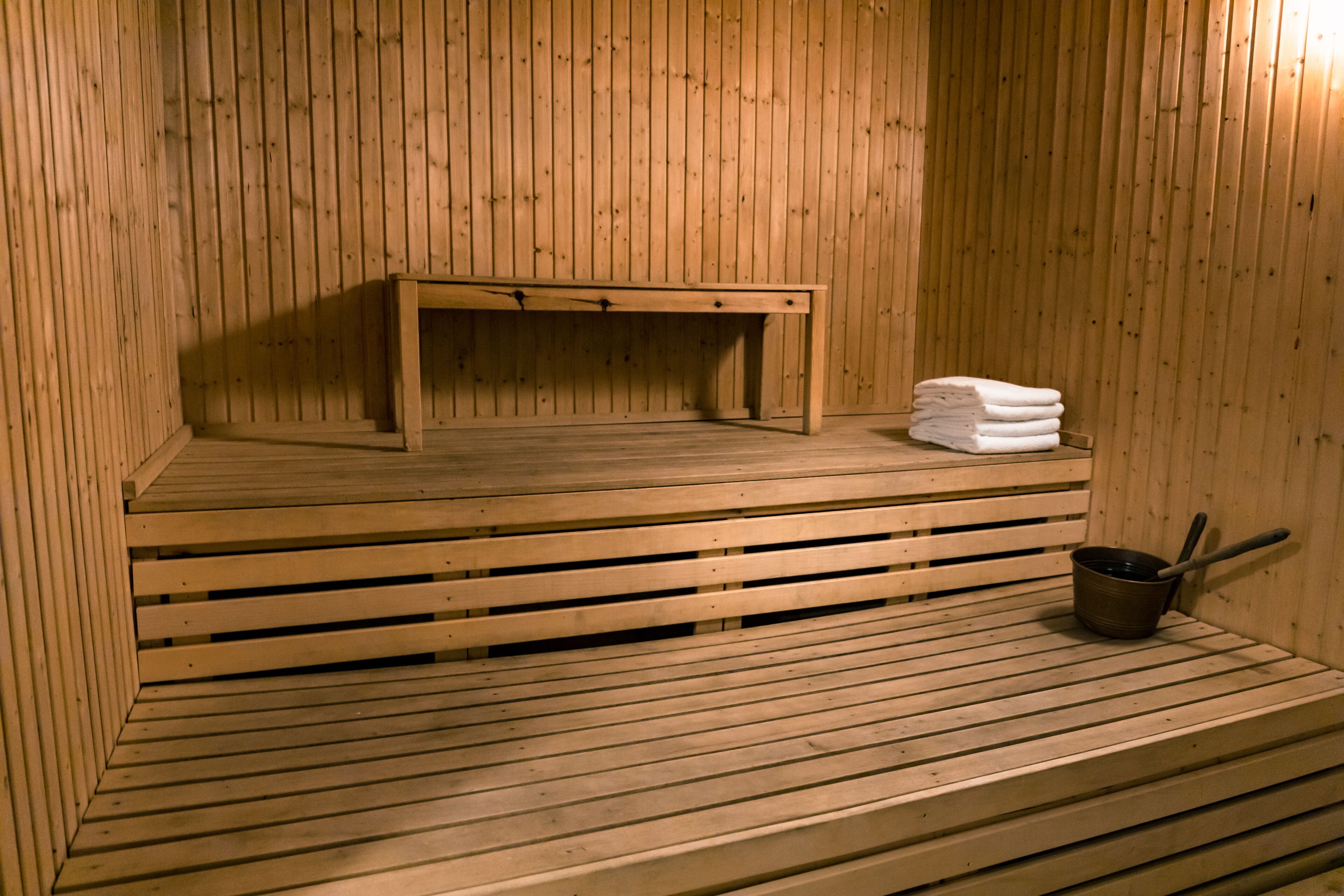 A wooden sauna with benches and a small table.