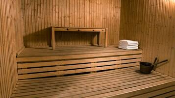 A wooden sauna with benches and a small table.