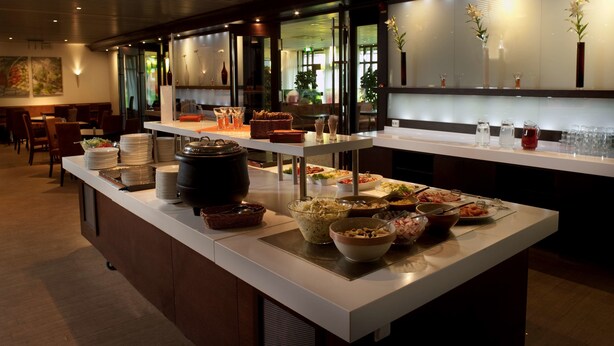 A buffet setup with various food items and serving utensils. - Best Western Hotel Scheele (Köping)