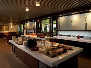 A buffet setup with various food items and serving utensils. - Best Western Hotel Scheele (Köping)