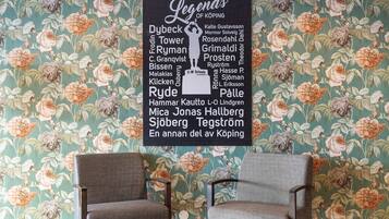 A room with floral wallpaper and two chairs.