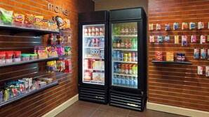 Espaço de distribuição automática com prateleiras repletas de diversos lanches e bebidas.