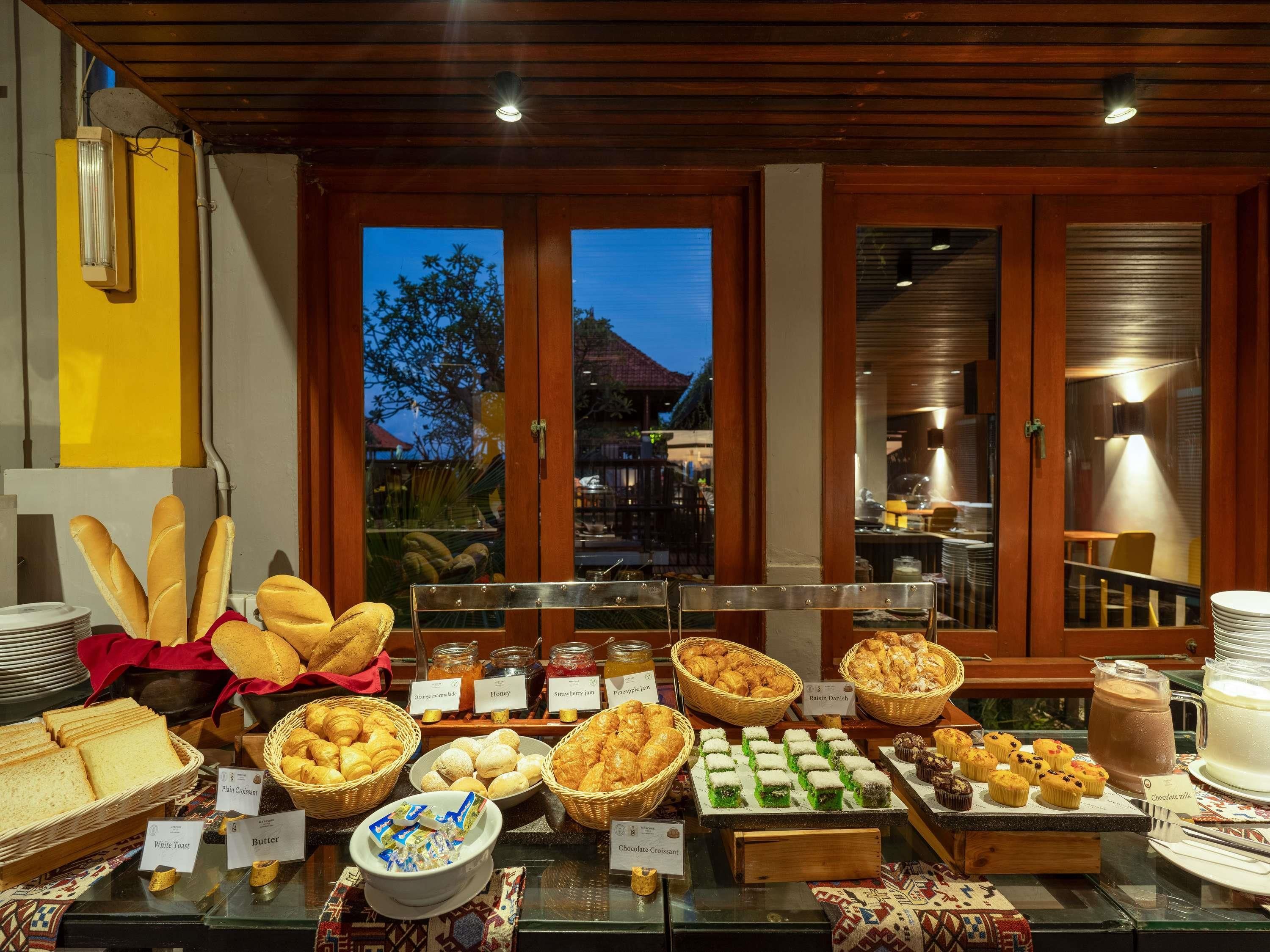 A buffet with various food items and labels, including bread, pastries, and desserts.