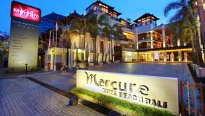 Entrada de un hotel con un cartel que dice "Mercure Kuta Beach Bali".