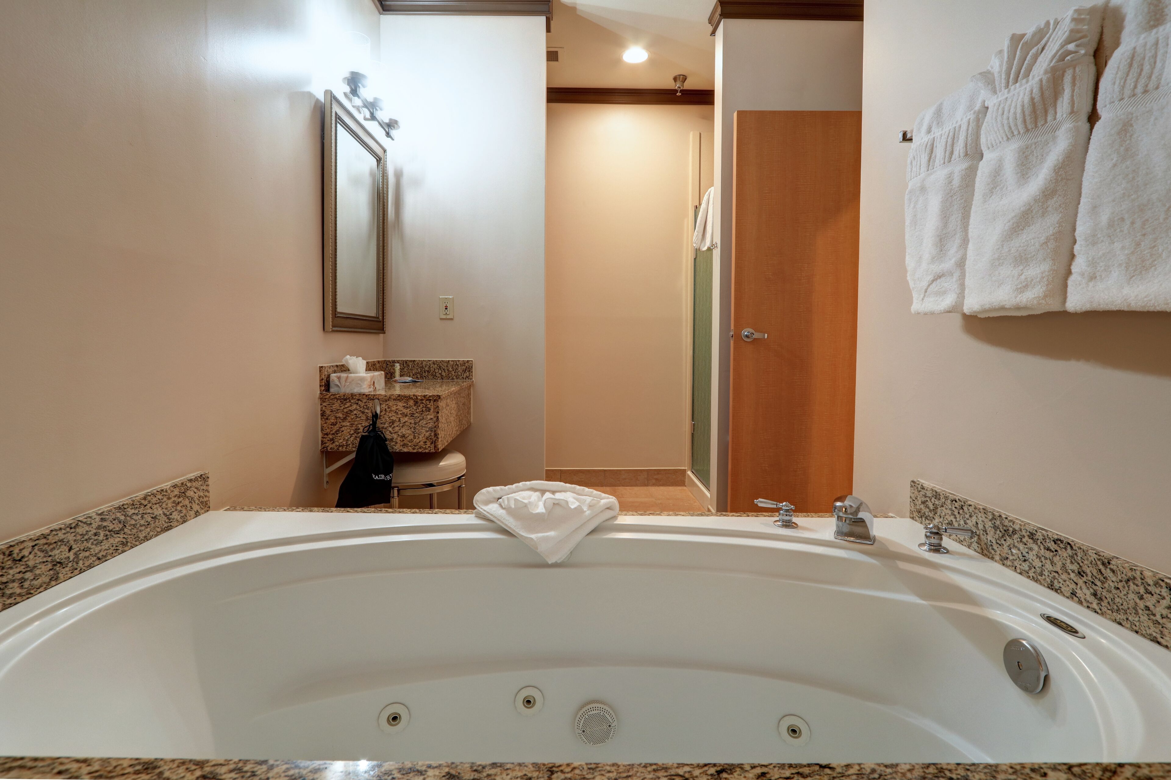 Un baño con una bañera grande, un espejo, un lavabo y una zona de ducha.
