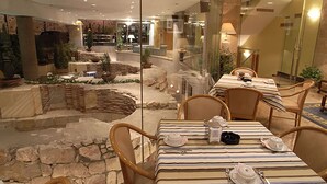 Un restaurante con pared de vidrio que ofrece vistas a un jardín exterior.
